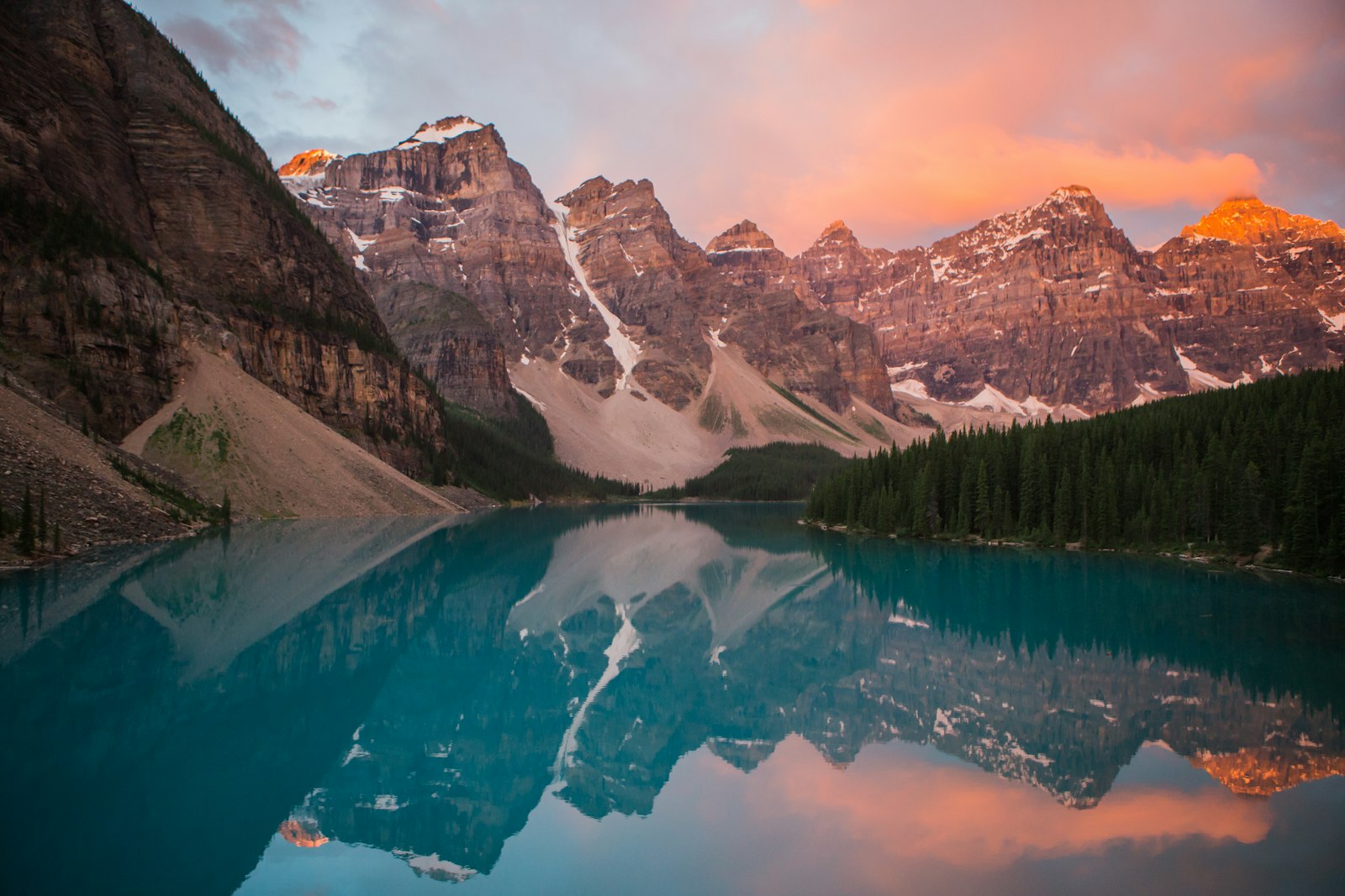 an alpine lake ringed by mountains in soft morning light