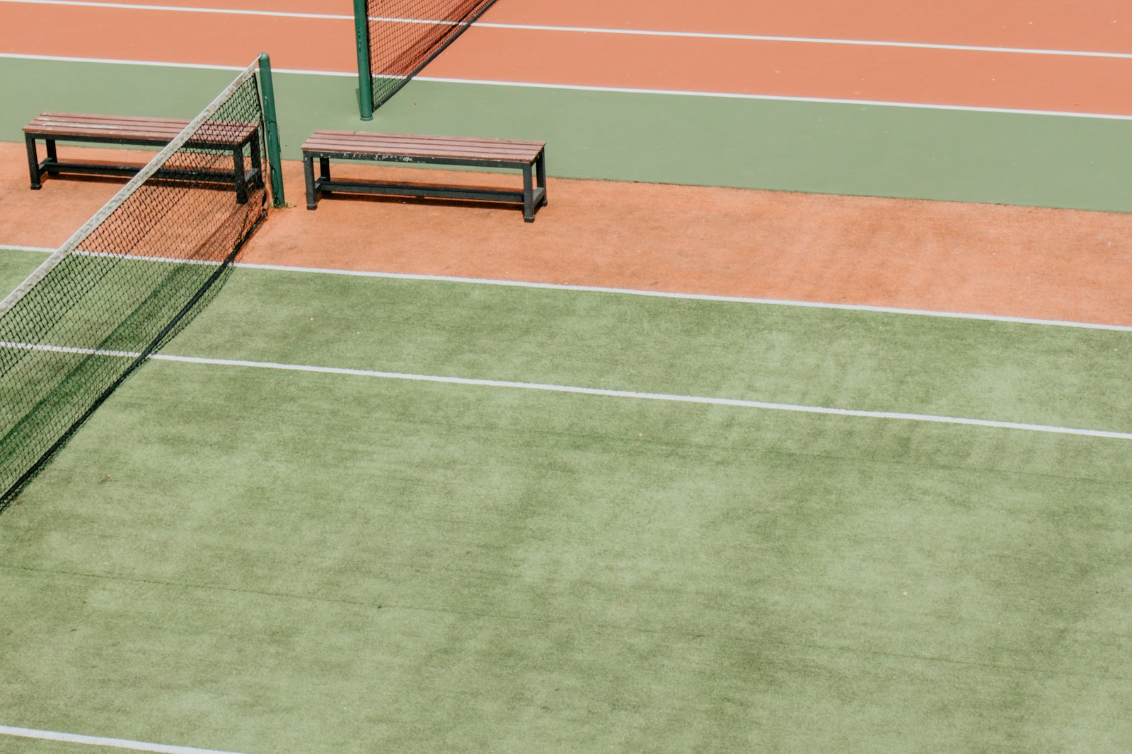 a quiet court with a courtside bench in morning shade